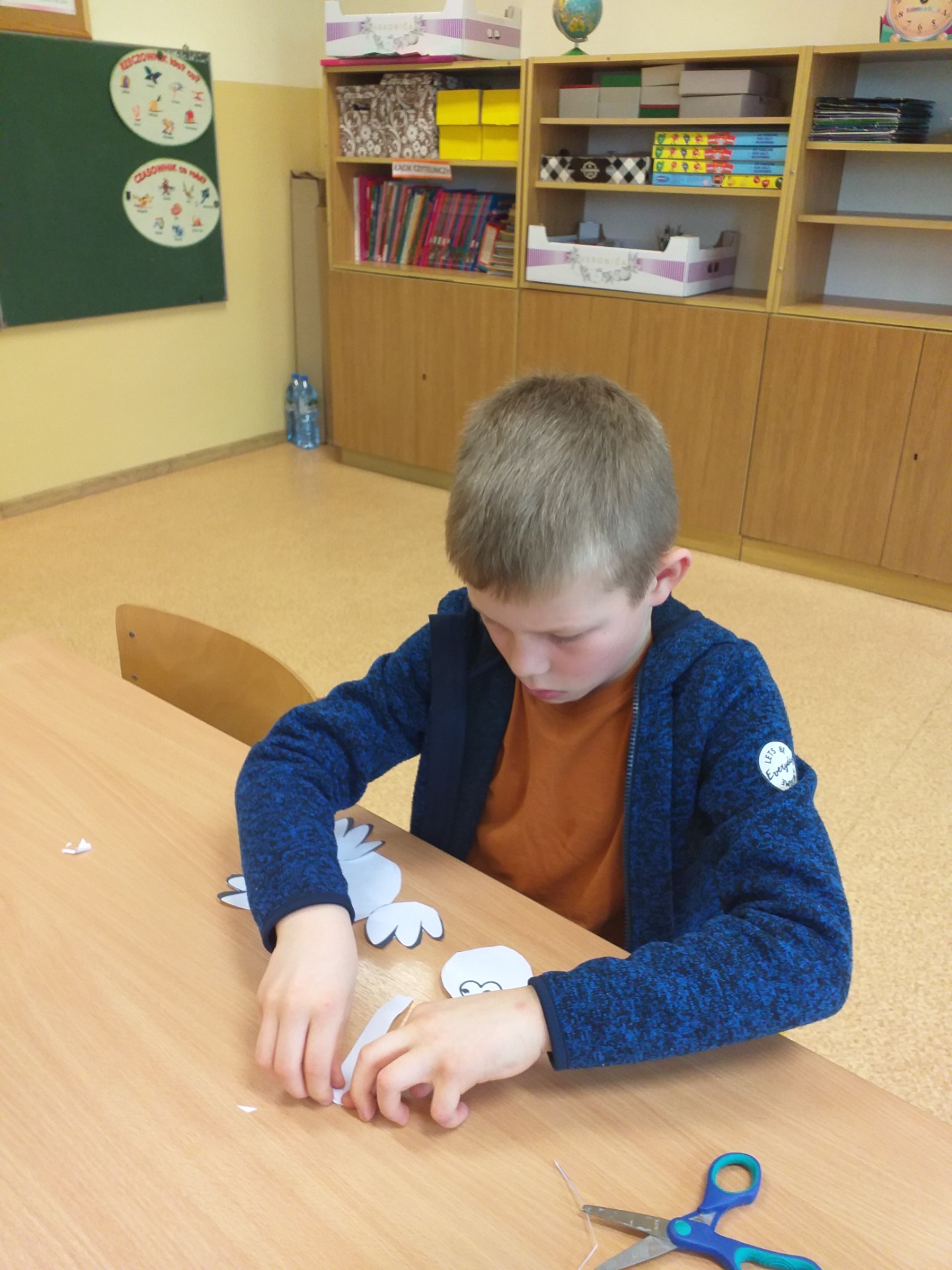 Lekcja plastyki - uczeń wykonuje papierowego bociana.