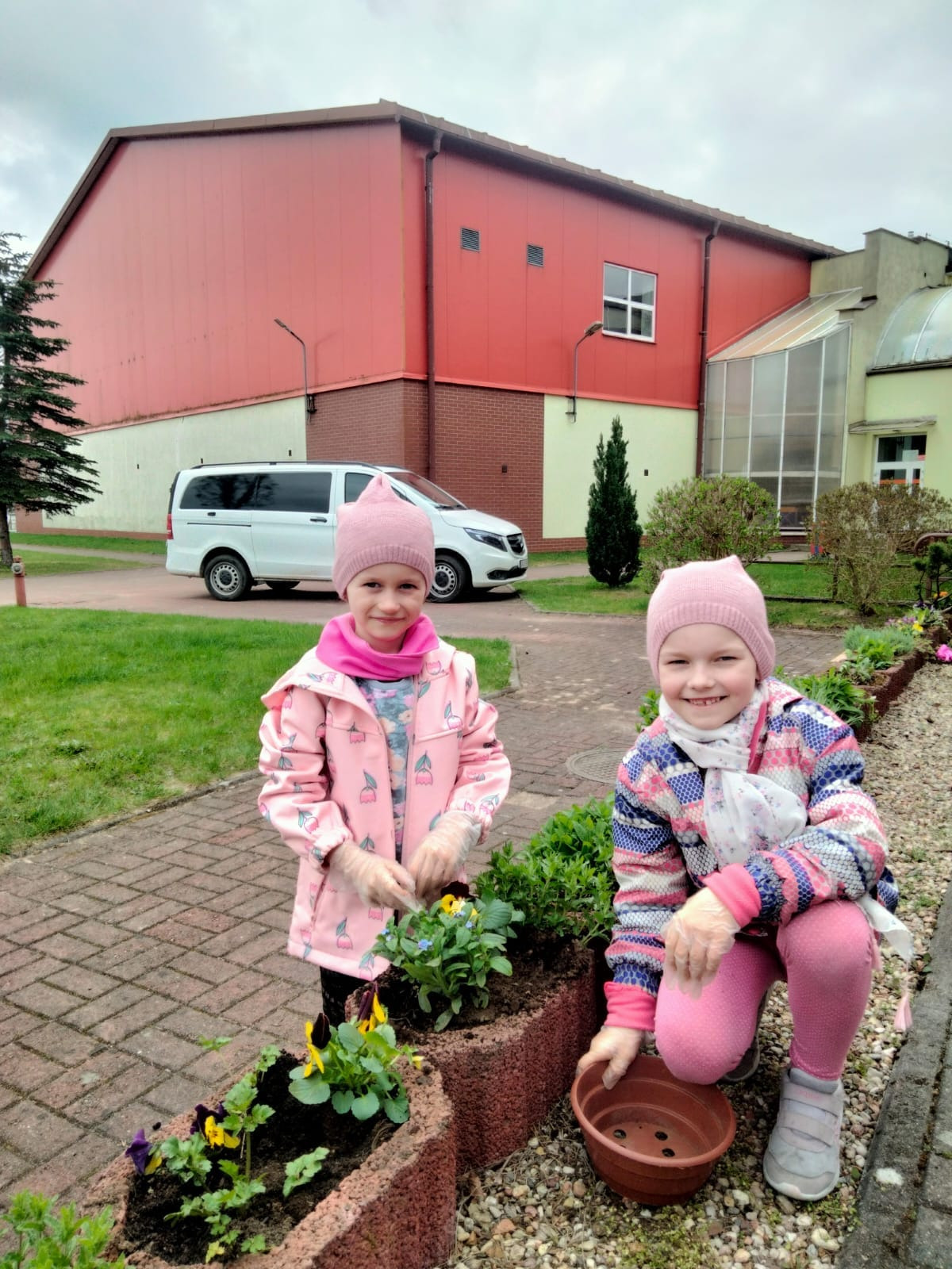 Dziewczynki sadzą kwiaty. 