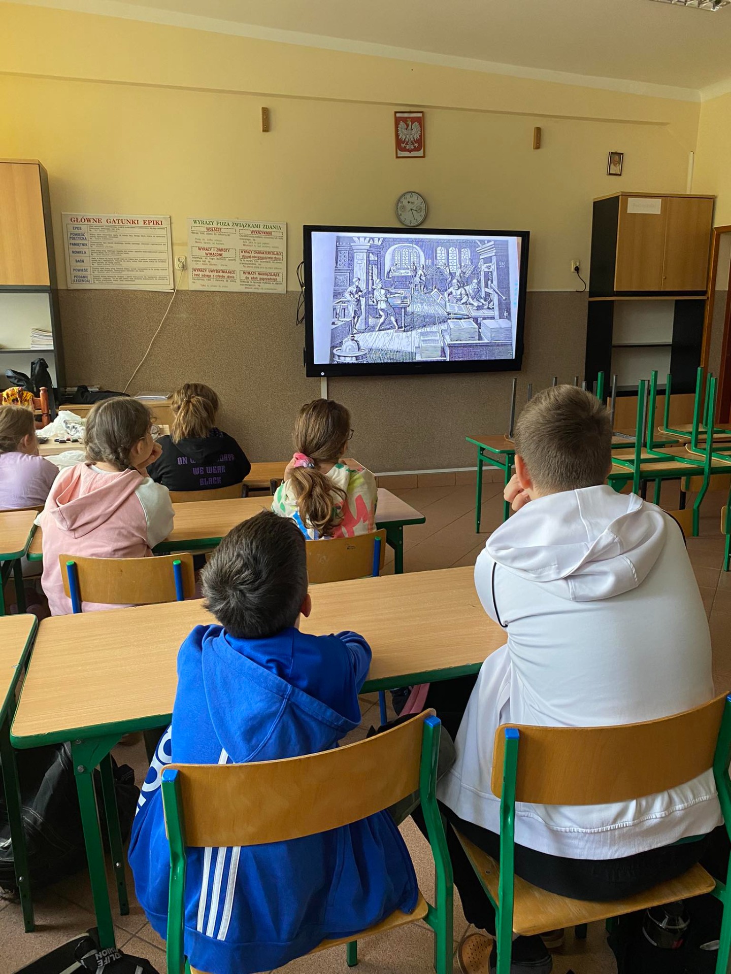 Uczniowie oglądają film o Janie Gutenbergu na tablicy interaktywnej