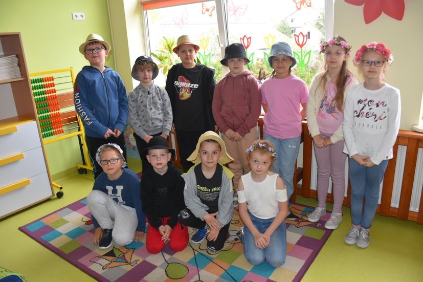 Grupa uczniów w kapeluszach i wiankach na głowie