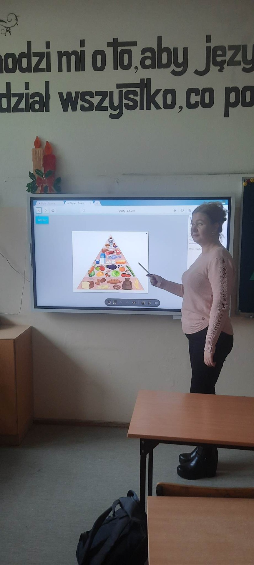 Program "Warzywa i owoce w szkole". Nauczyciel omawia specyfikę piramidy żywienia.