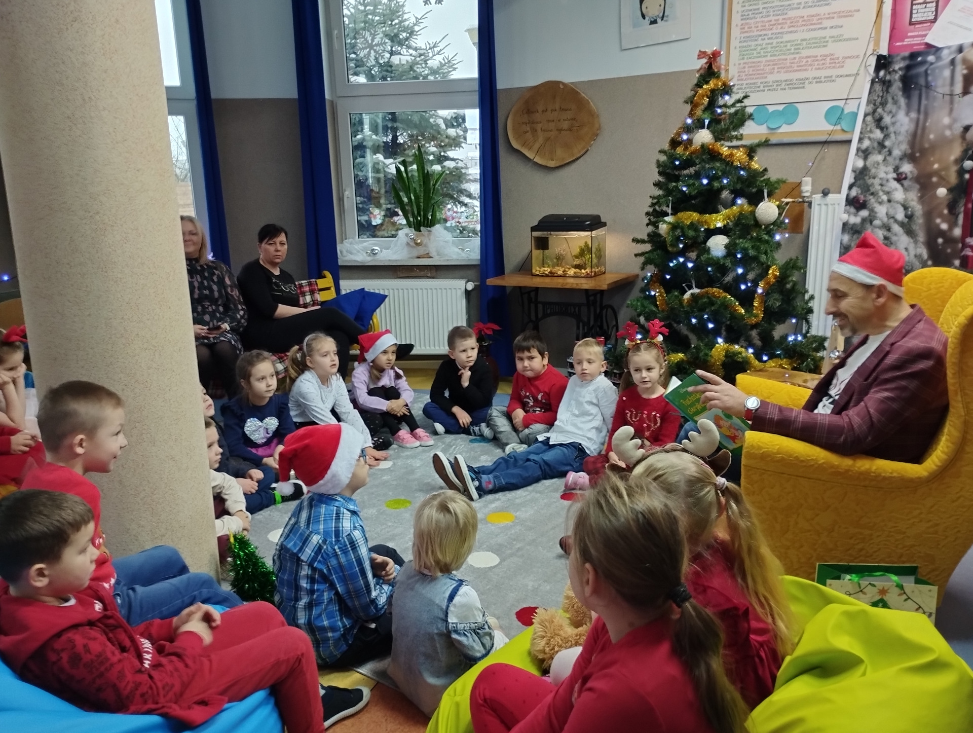 Dzieci z uwagą słuchają czytanej książeczki przez Zastępcę Burmistrza