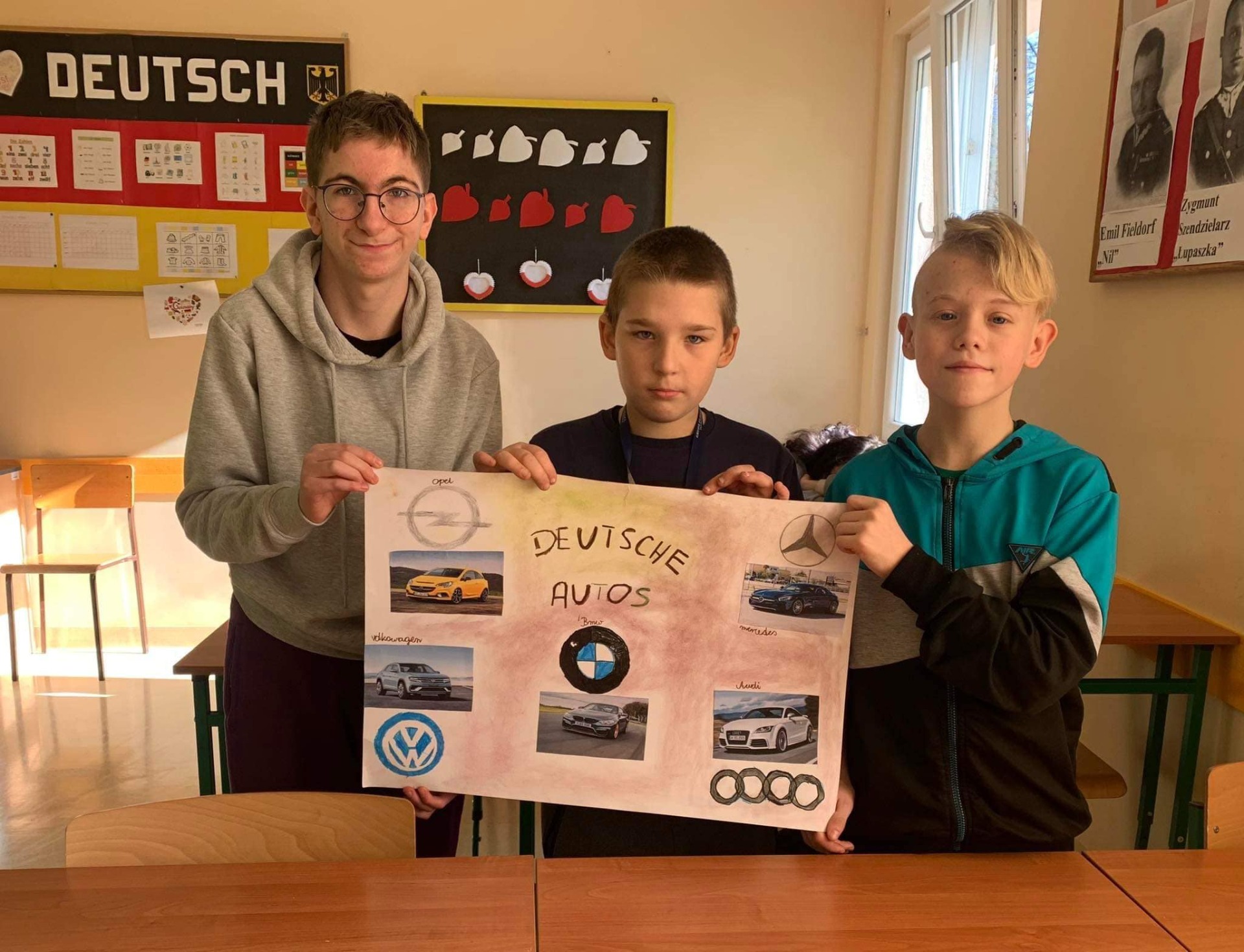 Radek, Kuba i Adam wraz z wykonanym przez siebie plakatem dotyczącym niemieckiej motoryzacji.