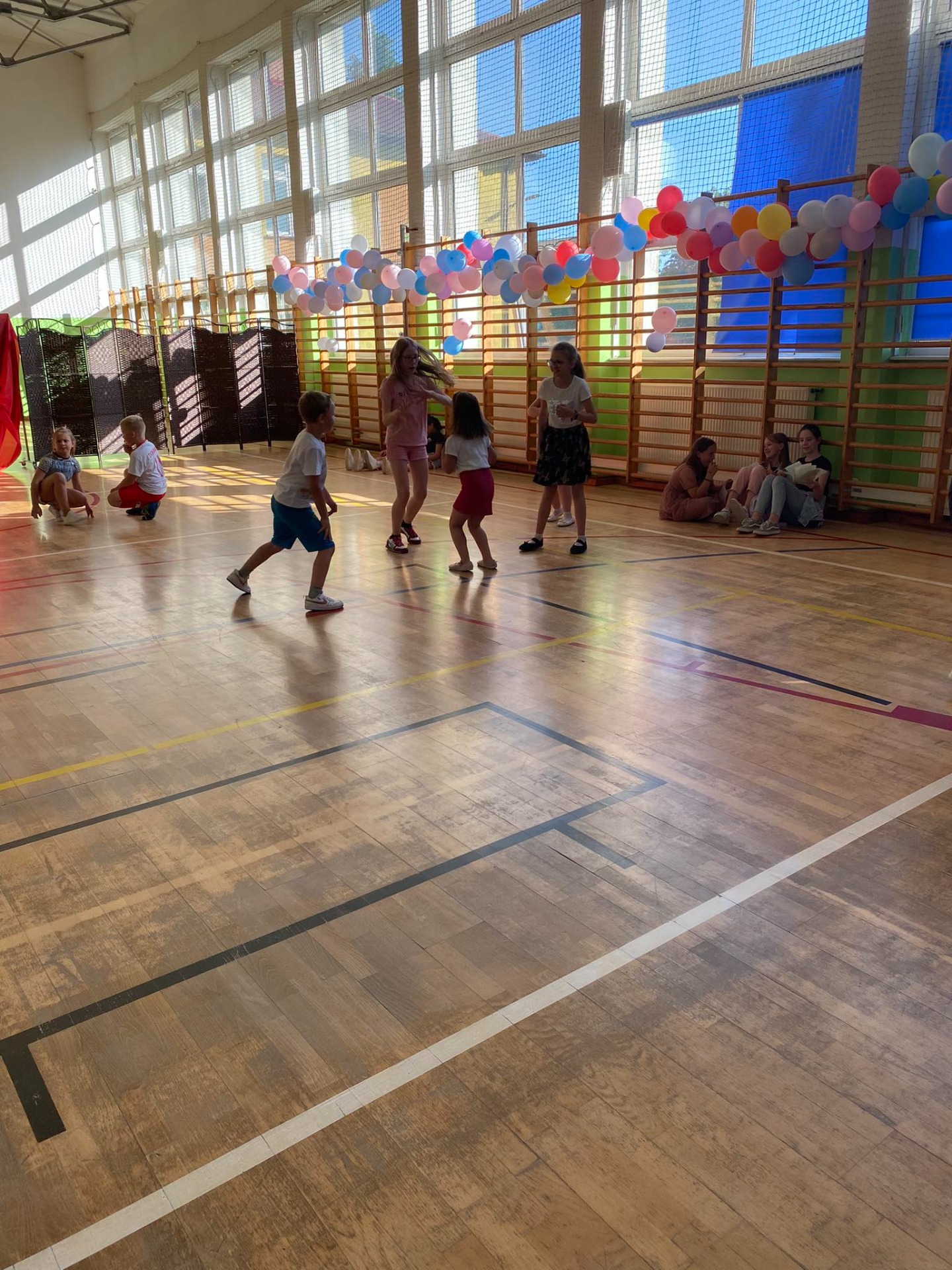 Grupa uczniów bawi się na sali gimnastycznej