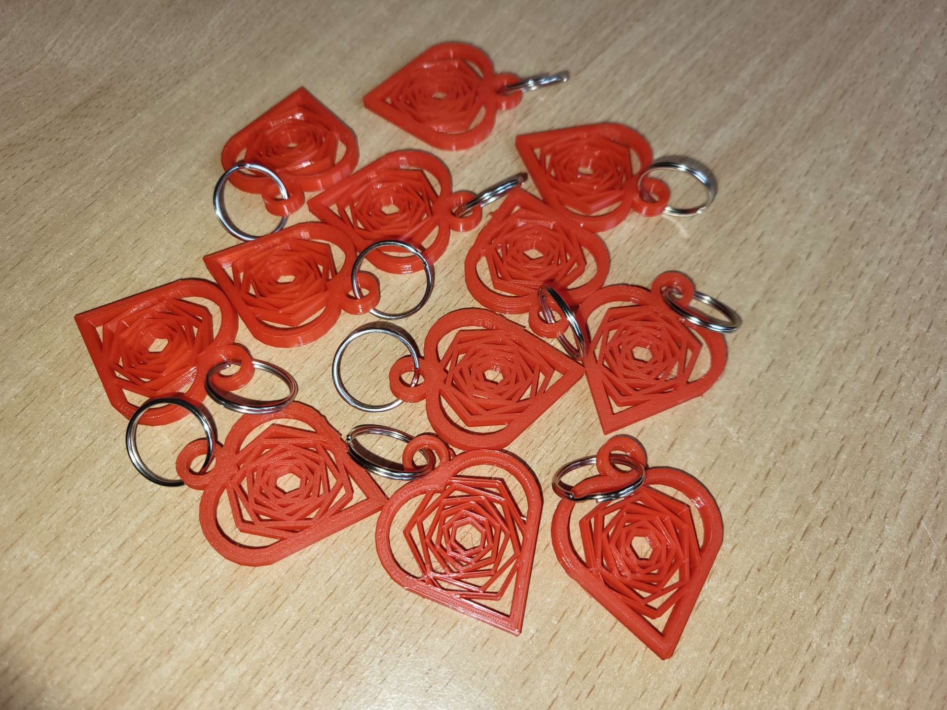 Czerwone breloczki w kształcie serca wykonane na drukarce 3D na srebrnym kółeczku do kluczy.